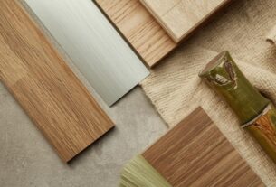 Detalhe editorial de materiais sustentáveis — madeira certificada, alumínio, linho natural e bambu — materiais para arquitetura efêmera dispostos sobre superfície de concreto.