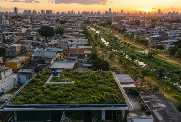 Telhado verde em bairro denso com parque linear ao fundo, exemplo de infraestrutura verde urbana