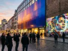 capa fachada com material adaptável mudando de cor ao entardecer em espaço urbano com arte de projeção